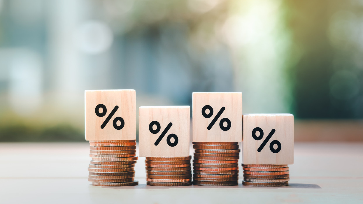 Interest rate finance and mortgage rates. Wooden block with percentage sign on many level of stack of coin. Financial growth, interest rate increase, inflation, sale price and tax rise concept.